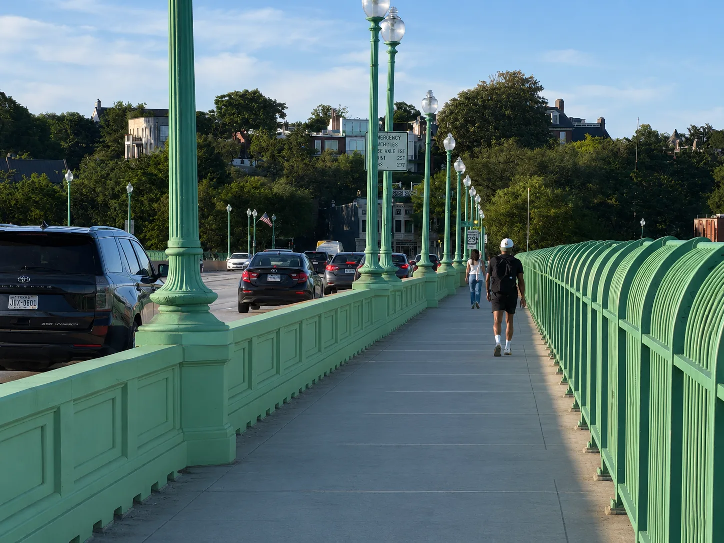 Visualization of the same sidewalk with the barrier wall coated in the bridge's signature green, unifying the crossing